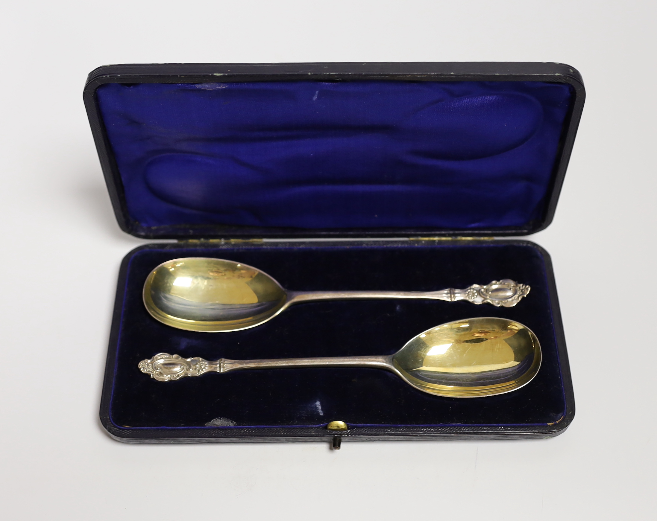 A cased pair of Edwardian parcel gilt silver serving spoons, Josiah Williams & Co Ltd, London, 1906, 19.6cm.